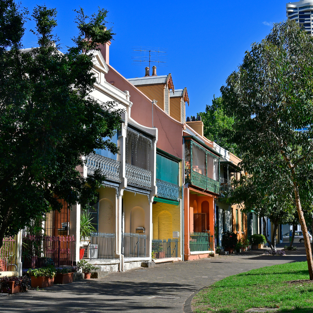 A row of townhouses with trees in the background.